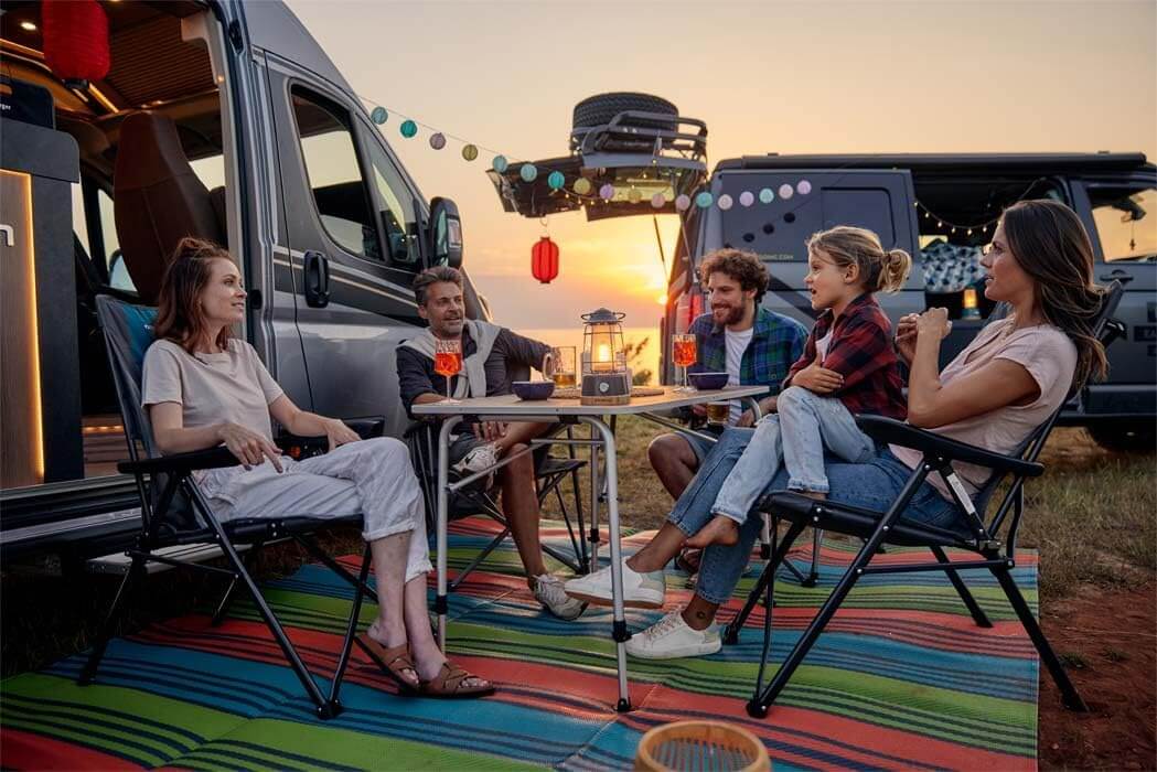 Група хора, наслаждаващи се на вечер пред надуваем форселт за каравана и кемпер: как да изберете правилния размер и материал