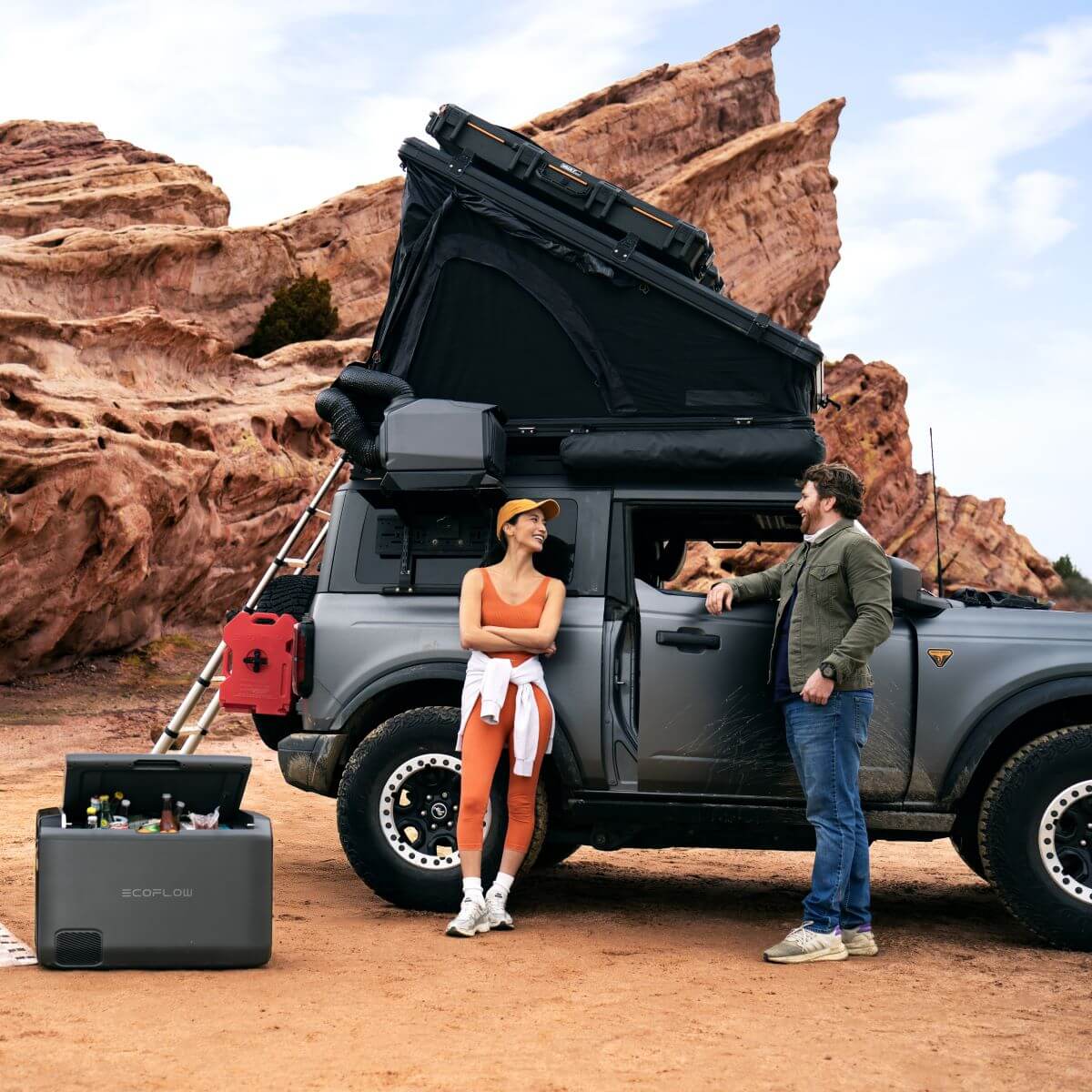 Outdoor camping setup with EcoFlow Glacier car fridge beside camper in a desert landscape, ideal for camping and travel enthusiasts.