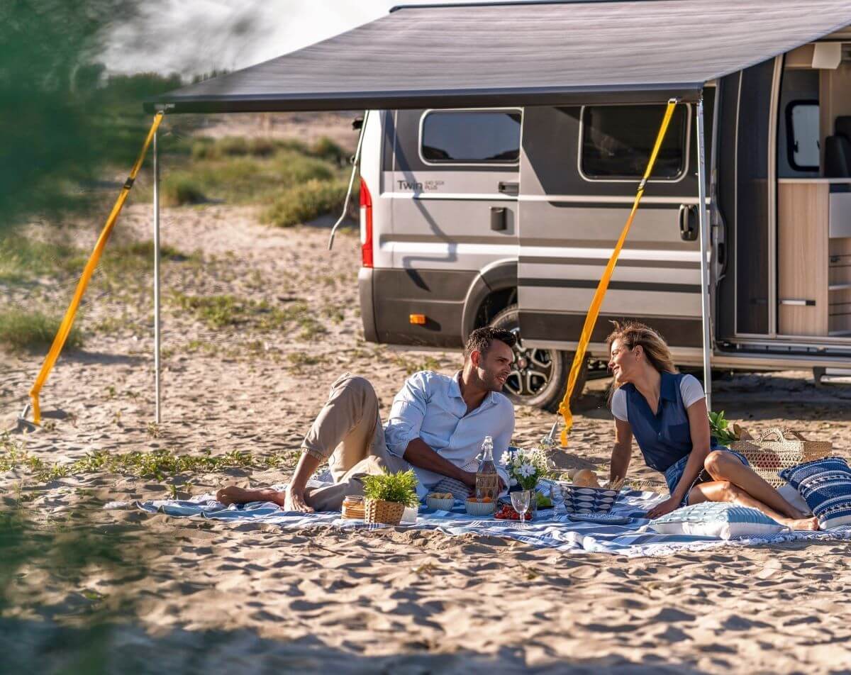 Enjoying a beach picnic under camper van awning supported by Колани за укрепване на тента Fiamma Tie Down S 300 см – комплект.