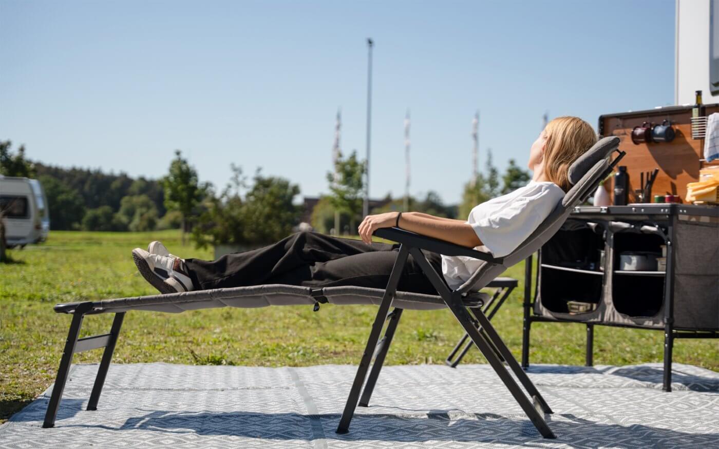 Жена релаксира на Лежанка за стол Berger Dakar на къмпинг с удобен, качествен луксозен дизайн от Gocampy.