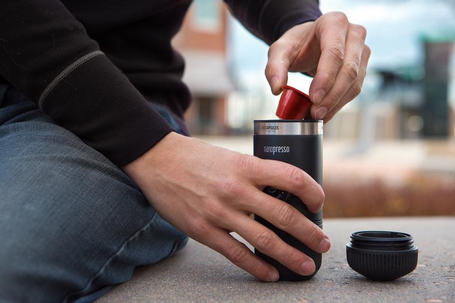 Човек използва преносимата машина за кафе еспресо Wacaco® Nanopresso на открито.